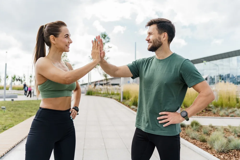 Couple high fiving - Tobin C Gallawa DPM FACFAS A young couple high fiving before a run - Tobin C Gallawa DPM FACFAS